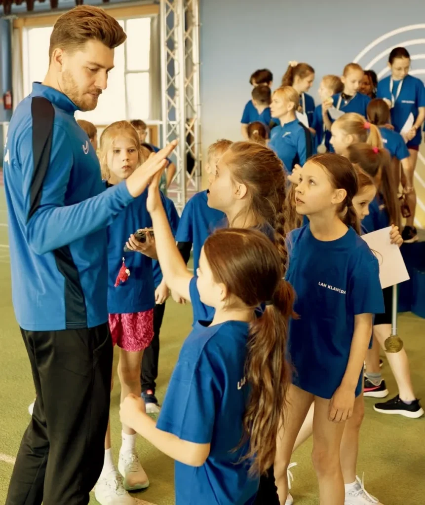 A coach with young LAM athletes in the indoor arena